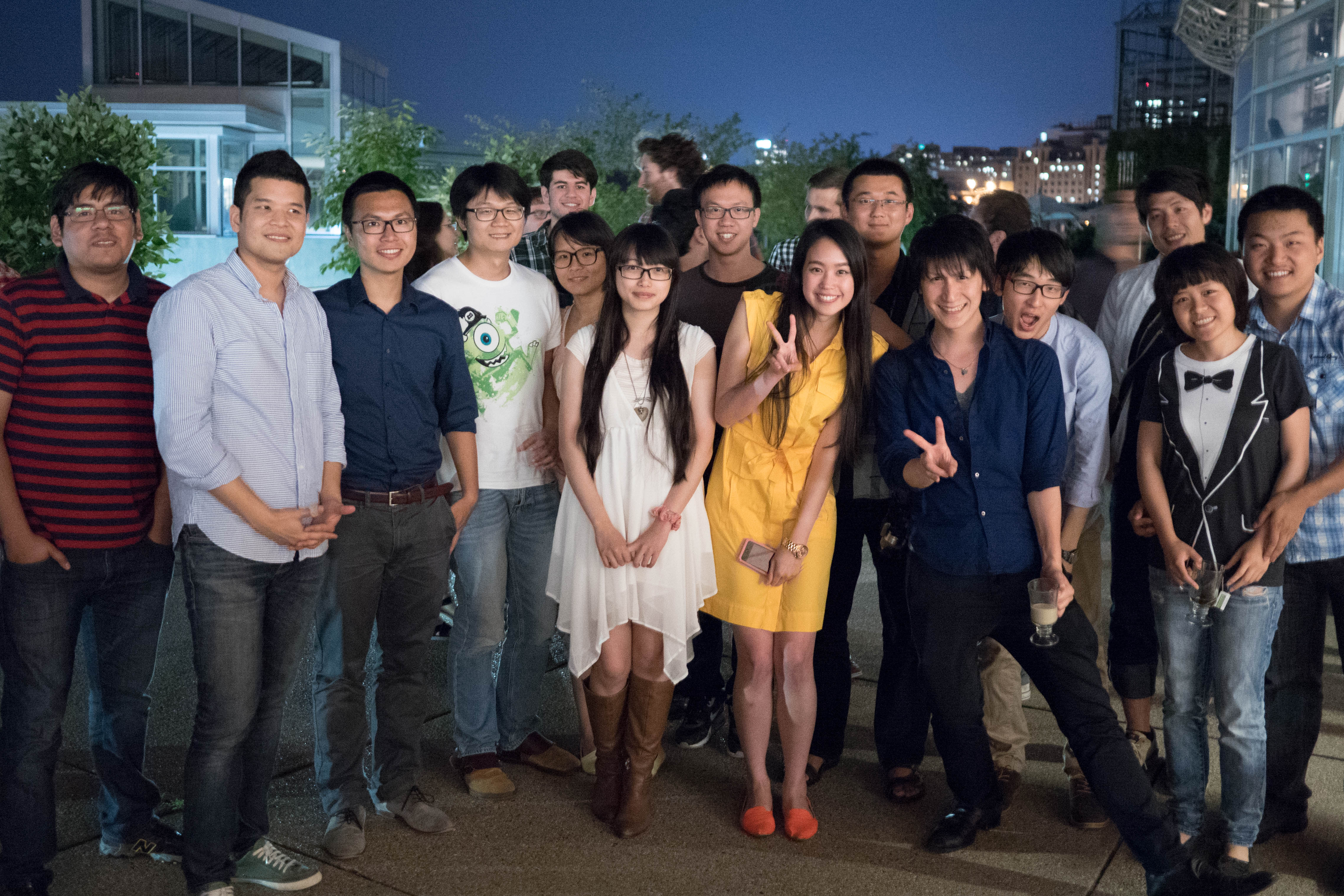 Group of about 20 MLSS 2014 participants posing outdoors at night, city lights visible in the background